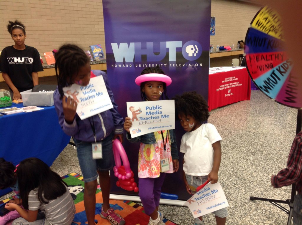 Sisters pose with their postcards at a WHUT event. 